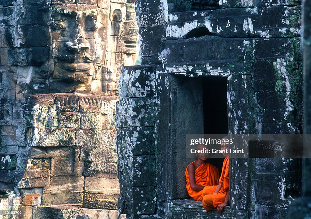 CAMBODIAN MONKS SIT IN ANGKOR WAT