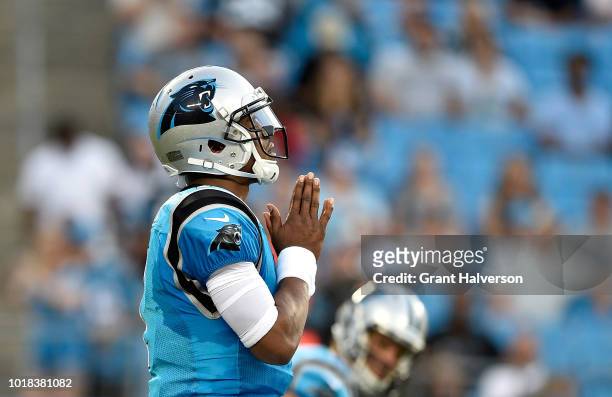 Cam Newton of the Carolina Panthers says a prayer at the line before the first play against the Miami Dolphins at Bank of America Stadium on August...