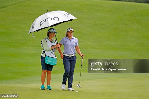 Golfer Brooke Henderson lines up a putt in the rain on the 18th hole during the second round of the Indy Women In Tech on August 17, 2018 at the...