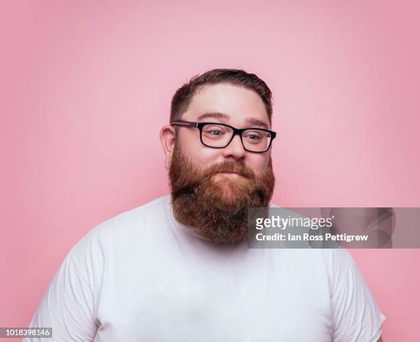 large bearded man on pink background - man expressive background glasses stock-fotos und bilder