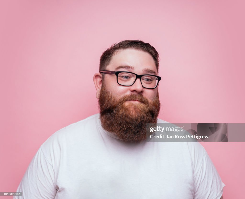 Large bearded man on pink background