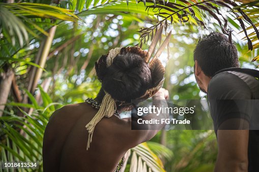 Indigenous Brazilian Young Man from Guarani ethnicity Showing the Rainforest to Tourist Indigenous Brazilian Young Man from Guarani ethnicity Showing the Rainforest to Tourist
