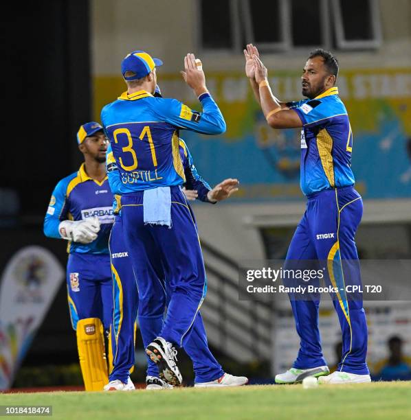 In this handout image provided by CPL T20, Wahab Riaz and Martin Guptill of Barbados Tridents celebrate the dismissal of Lendl Simmons of St Lucia...