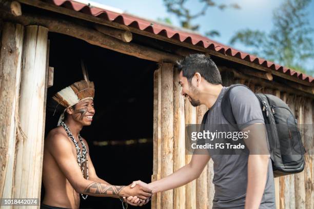 indígenas brasileños jóvenes hombre retrato de etnia guaraní, dar la bienvenida al turista - cultura indígena fotografías e imágenes de stock