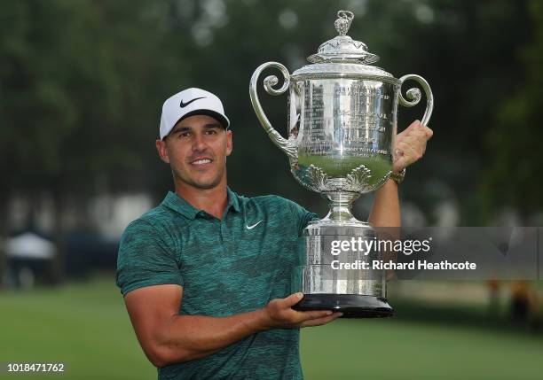 Brooks Koepka of the United States celebrates with the Wanamaker Trophy on the 18th green after winning the 2018 PGA Championship with a score of -16...