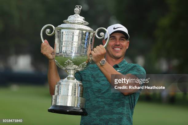 Brooks Koepka of the United States celebrates with the Wanamaker Trophy on the 18th green after winning the 2018 PGA Championship with a score of -16...