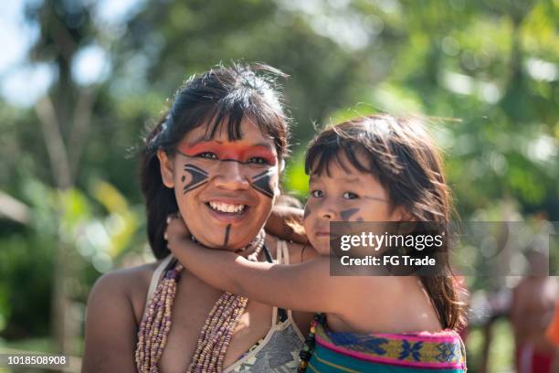 indígenas brasileñas jóvenes y su hijo, retrato de tupi guaraní etnia - cultura indigena fotografías e imágenes de stock