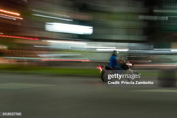 man riding a motorcycle at night - passeio em veículo motorizado imagens e fotografias de stock