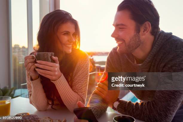 young couple drinking coffee at sunrise or sunset. - coffee on patio stock pictures, royalty-free photos & images