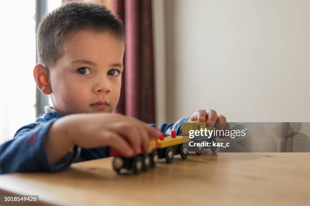 bambino che gioca con un treno giocattolo di legno - popolo eurasiatico foto e immagini stock