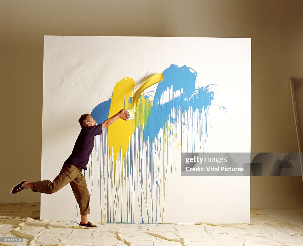 ARTIST THROWING PAINT AT CANVAS