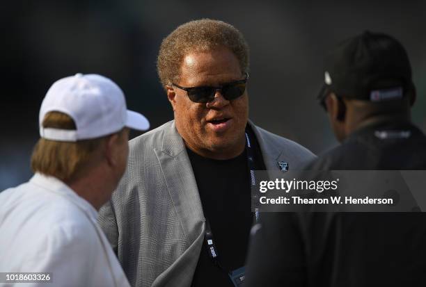 Owner Mark Davis and General Manager Reggie McKenzie of the Oakland Raiders talking with each other while looking on as their team warms up prior to...