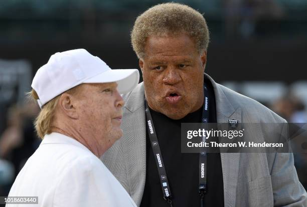 Owner Mark Davis and General Manager Reggie McKenzie of the Oakland Raiders talking with each other while looking on as their team warms up prior to...