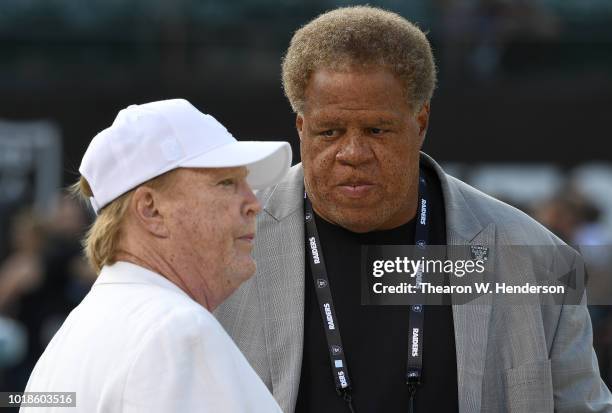 Owner Mark Davis and General Manager Reggie McKenzie of the Oakland Raiders talking with each other while looking on as their team warms up prior to...