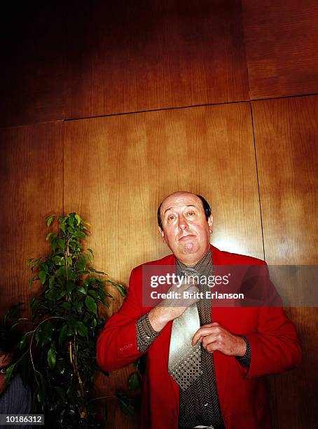 man in red jacket adjusting tie, portrait - cheesy salesman stock-fotos und bilder