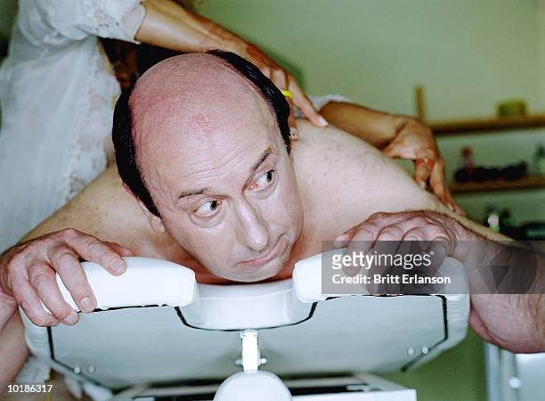 man on massage table being massaged - banc de massage photos et images de collection