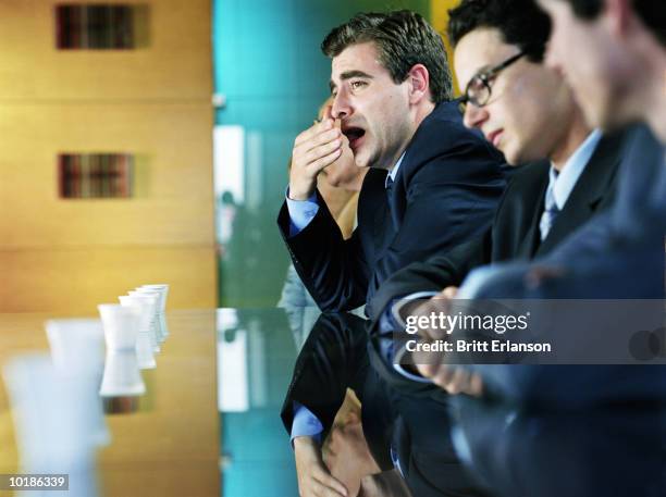 man yawning in meeting - yawning foto e immagini stock