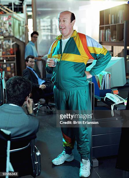 man wearing fitness gear in office - track suit stock pictures, royalty-free photos & images