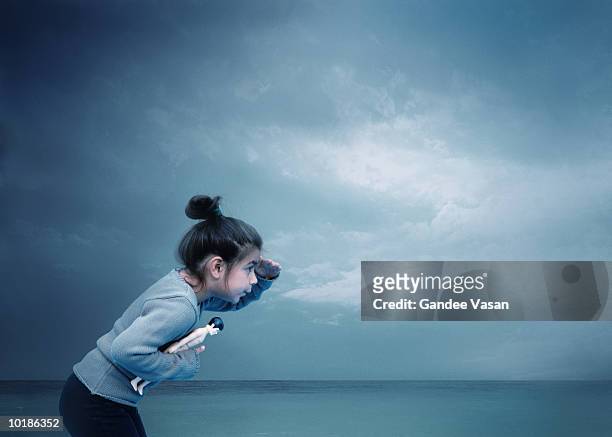 girl looking into distance by sea - facing things head on stock pictures, royalty-free photos & images