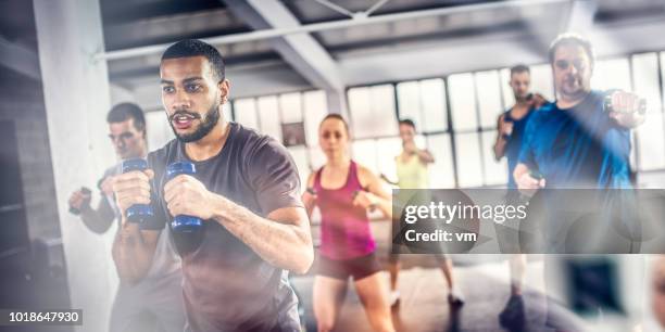 aerobics class shadow boxing with dumbbells - aerobics stock pictures, royalty-free photos & images