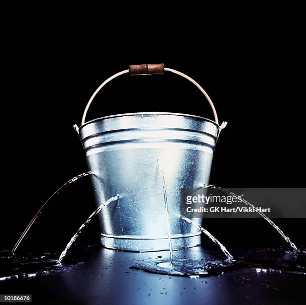 bucket with holes leaking water - bucket stock-fotos und bilder