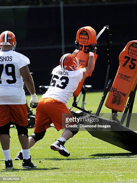 Offensive lineman Eric Ghiaciuc of the Cleveland Browns hits the blocking sled as teammate Tony Pashos looks on during the team's organized team...