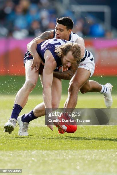 Tim Kelly of the Cats tackles David Mundy of the Dockers during the round 22 AFL match between the Geelong Cats and the Fremantle Dockers at GMHBA...