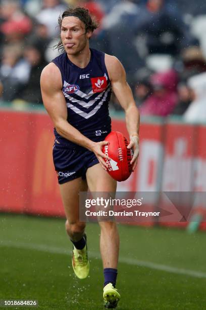 Ed Langdon of the Dockers runs with the ball during the round 22 AFL match between the Geelong Cats and the Fremantle Dockers at GMHBA Stadium on...