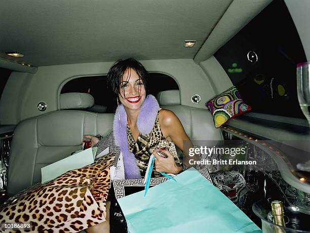 young woman in back of car surrounded by shopping bags, portrait - accro du shopping photos et images de collection