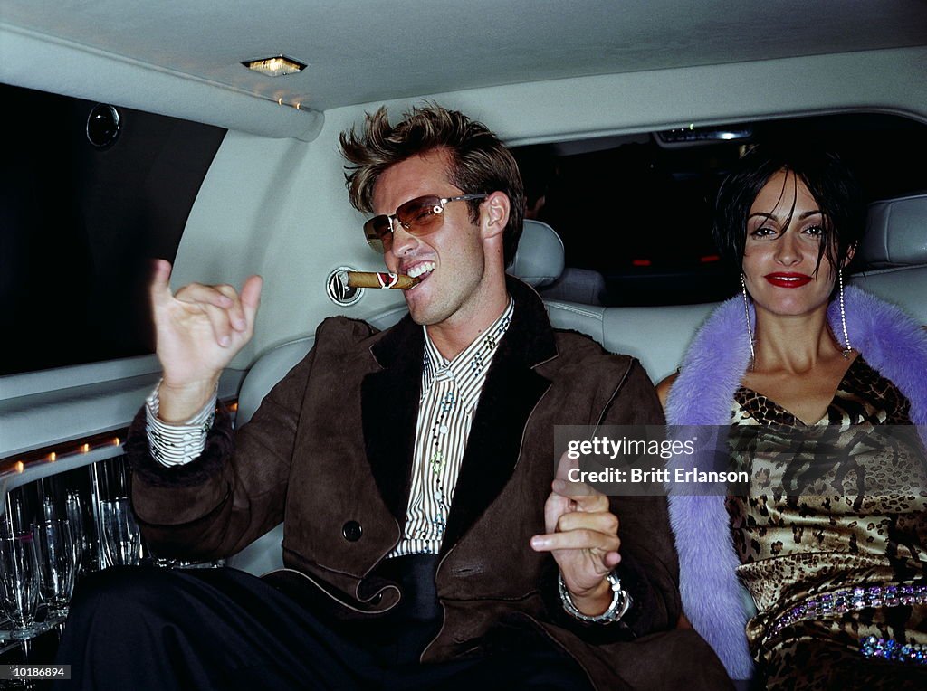 COUPLE IN BACK OF CAR, MAN WITH CIGAR, PORTRAIT