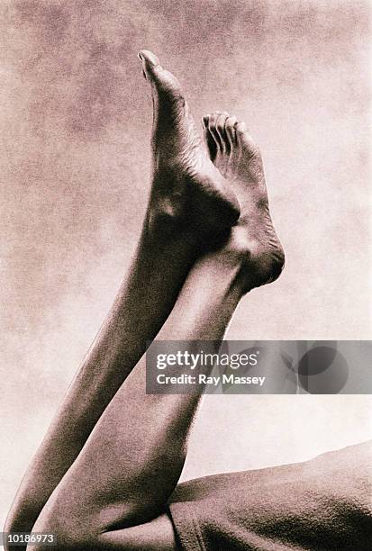 woman lying down, feet crossed in air (toned b&w) - woman lying on stomach with feet up stock pictures, royalty-free photos & images