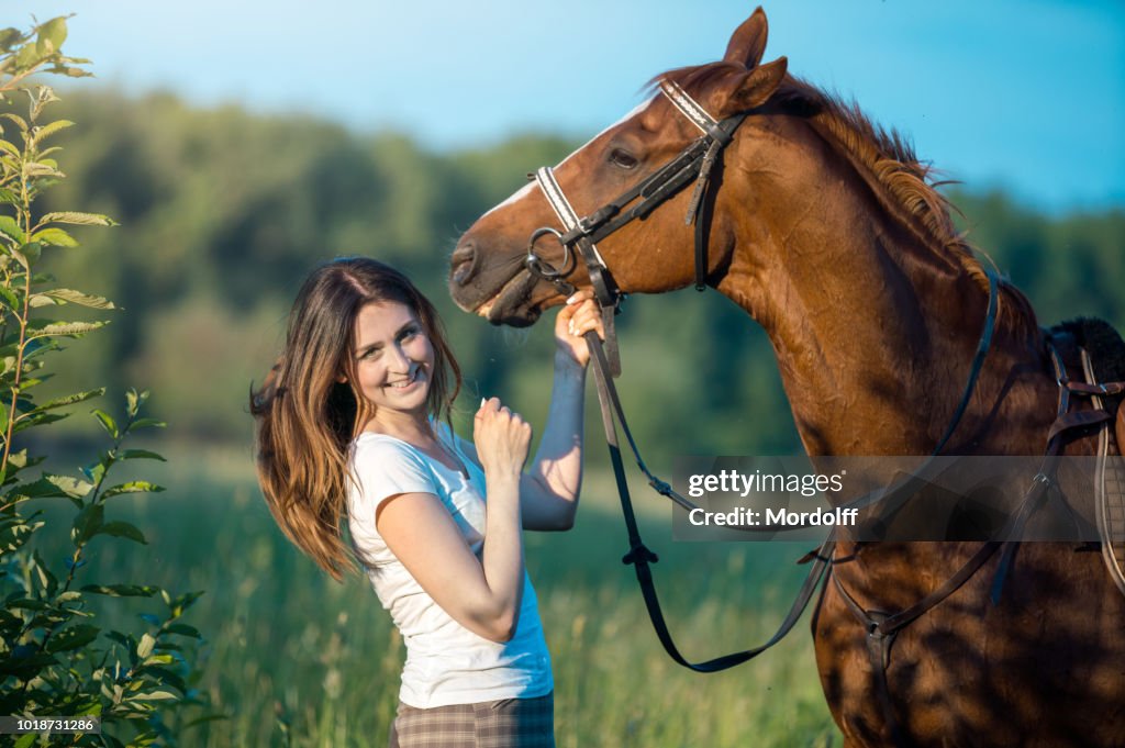 Mujer feliz con el caballo al aire libre