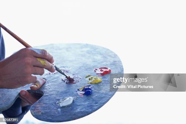 artist with palette and brush, close-up - paleta de cores imagens e fotografias de stock