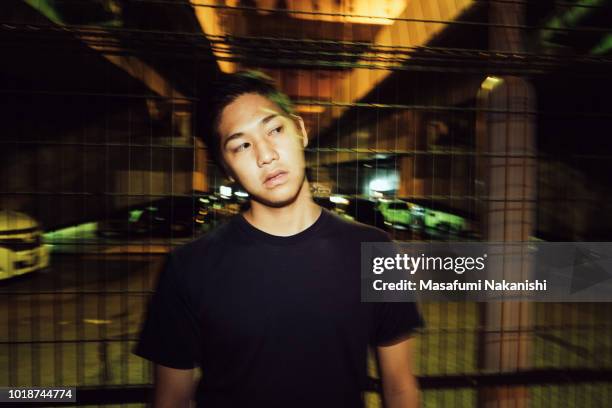 Portrait of contemporary young Japanese man at night street