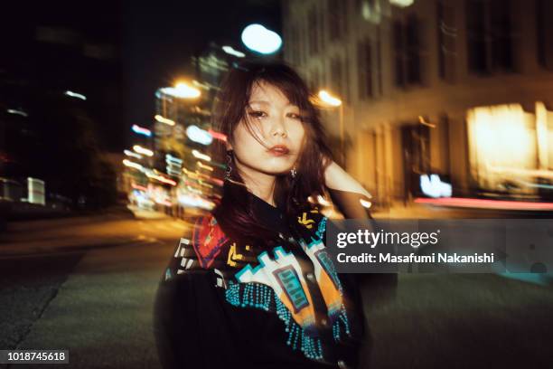 portrait of contemporary young japanese woman at night street - trends asian stock-fotos und bilder