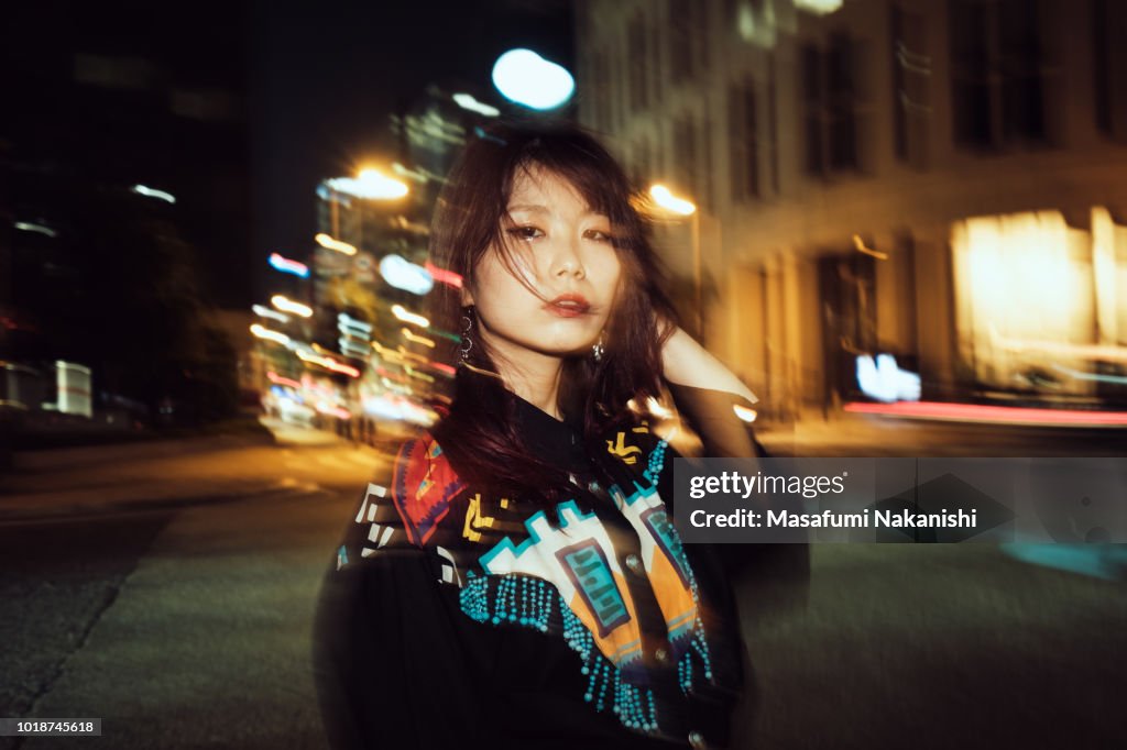 Portrait of contemporary young Japanese woman at night street