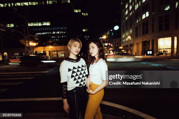 portrait of contemporary young japanese couple at night street - japan photos 個照片及圖片檔