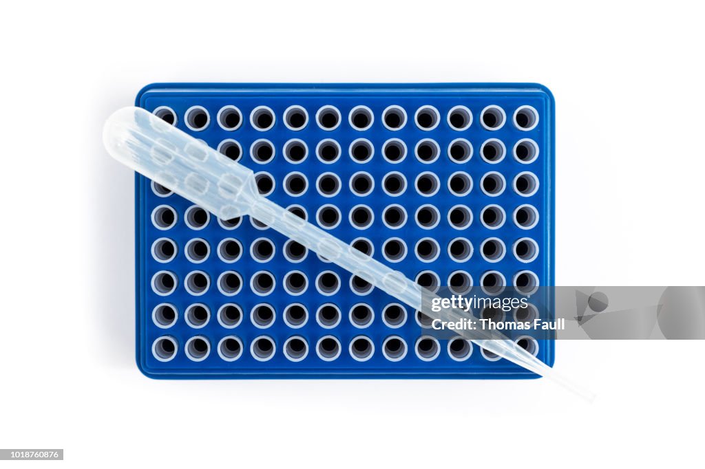 Microplate (wellplate) with many small test tubes with a pipette