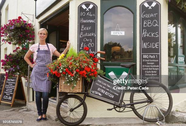 female butcher stood outside shop - sold palabra en inglés fotografías e imágenes de stock