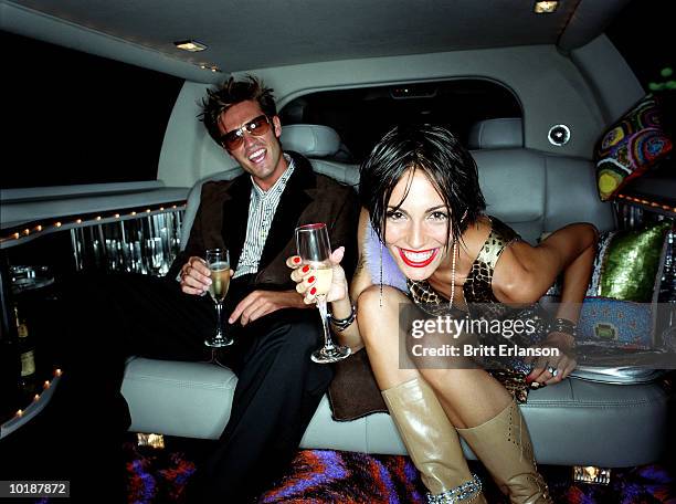 couple in back of car with champagne, smiling, portrait - limousine stock pictures, royalty-free photos & images