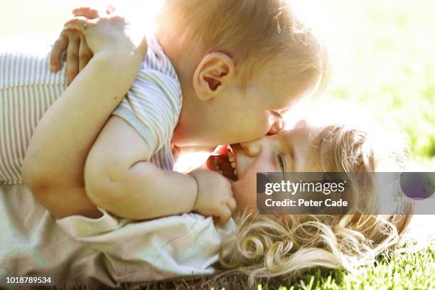 baby and sister playing on grass - sibling stock-fotos und bilder