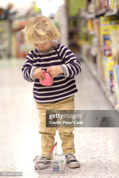 toddler looking in purse in shop - cream coloured purse stock pictures, royalty-free photos & images
