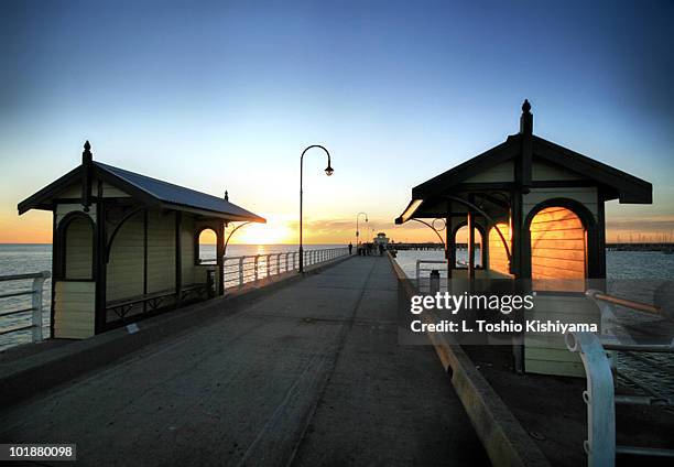 a long pier at sunset - st kilda beach stock pictures, royalty-free photos & images