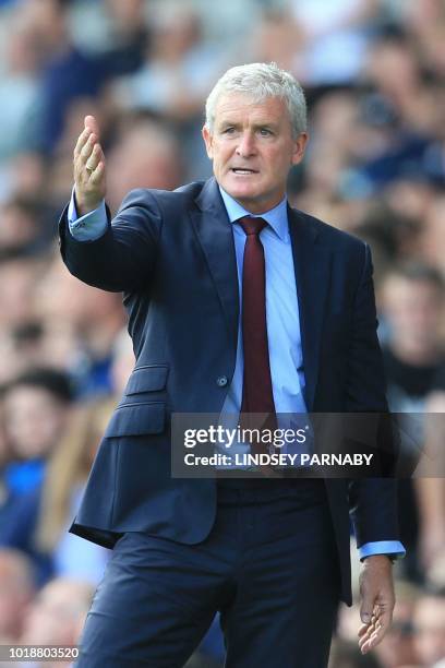 Southampton Welsh manager Mark Hughes reacts watches from the touchline during the English Premier League football match between Everton and...