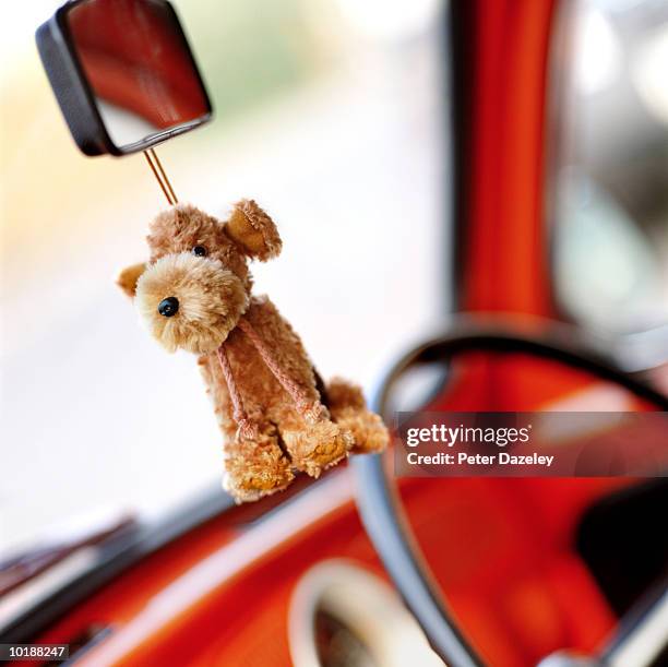 toy dog hanging on rear view mirror - toy dog fotografías e imágenes de stock