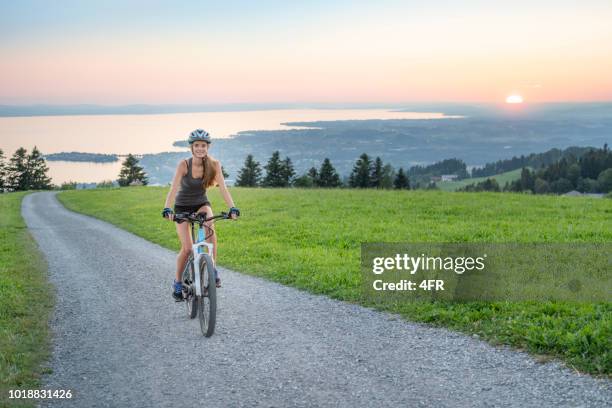 frau auf ihr mountainbike auf den berühmten berg pfänder, bodensee (bodensee) auf der rückseite, österreich - bodensee stock-fotos und bilder