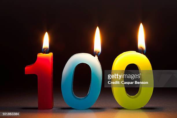 three candles in the shape of the number 100 - 100th anniversary photos et images de collection
