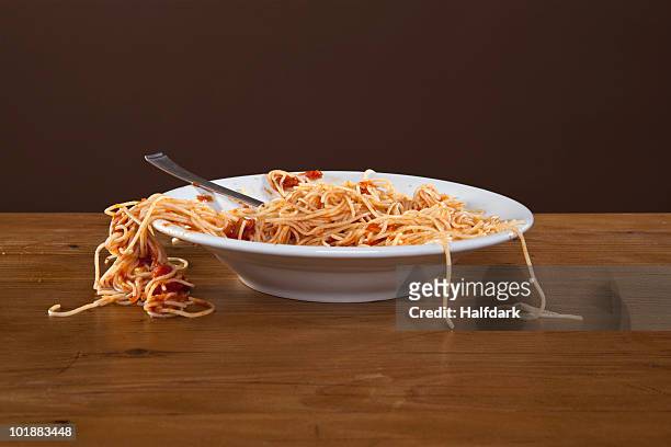 a messy plate of spaghetti, studio shot - spaghetti stockfoto's en -beelden