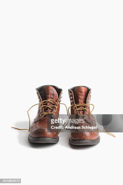a pair of worn work boots - calzature di pelle foto e immagini stock
