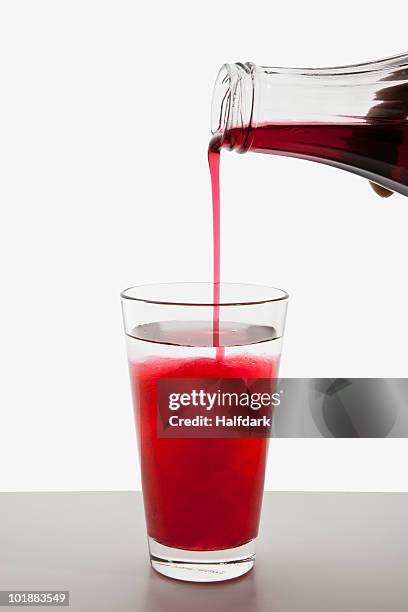 detail of fruit syrup being poured into a glass of water - sirup stock-fotos und bilder